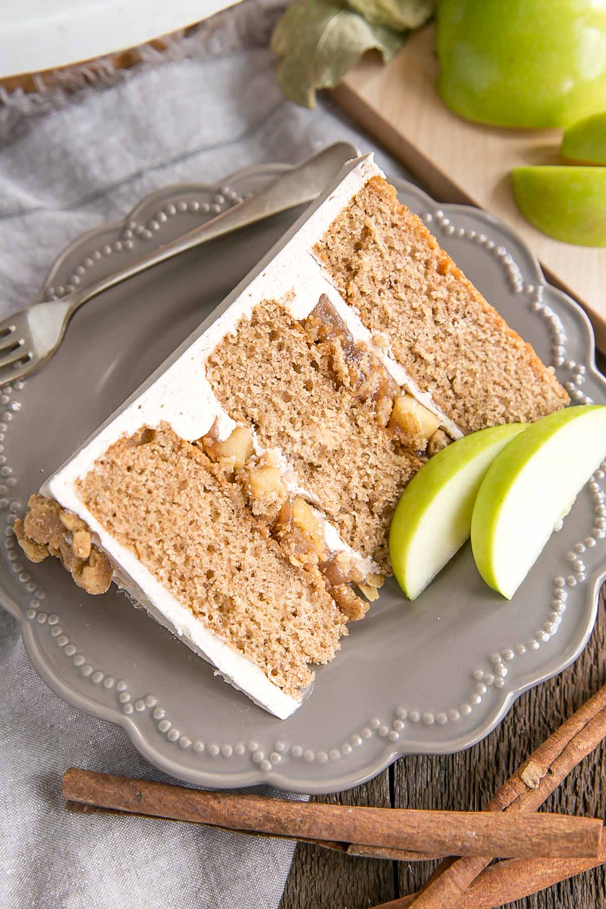 This Apple Crisp Cake pairs spice cake layers with a delicious homemade apple pie filling and apple crisp crumble. | livforcake.com Slice of cake showing apple pie filling and crumble.