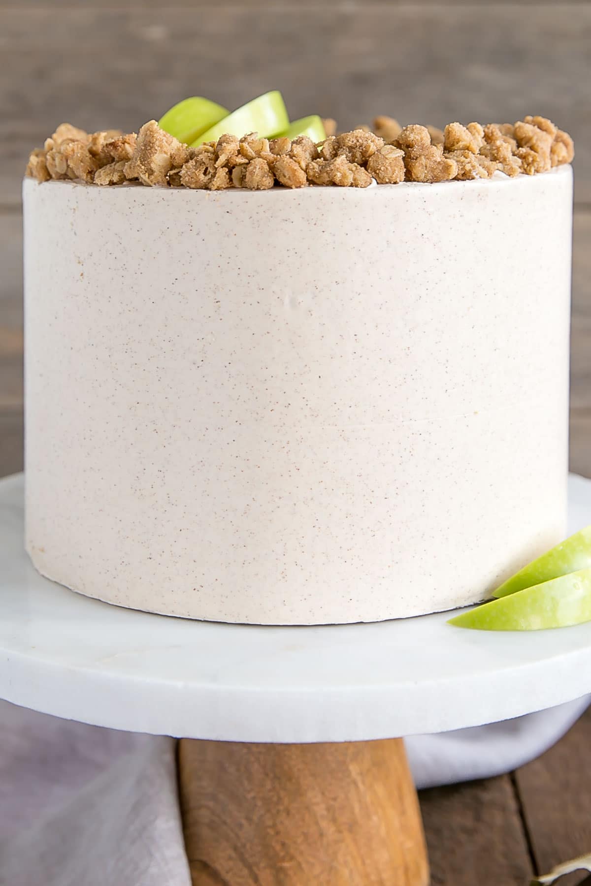 This Apple Crisp Cake pairs spice cake layers with a delicious homemade apple pie filling and apple crisp crumble. | livforcake.com Close up of the cake showing the Cinnamon buttercream.