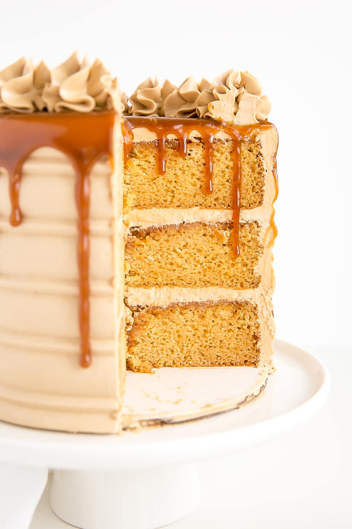 Cross section of a caramel cake with caramel dripping down.