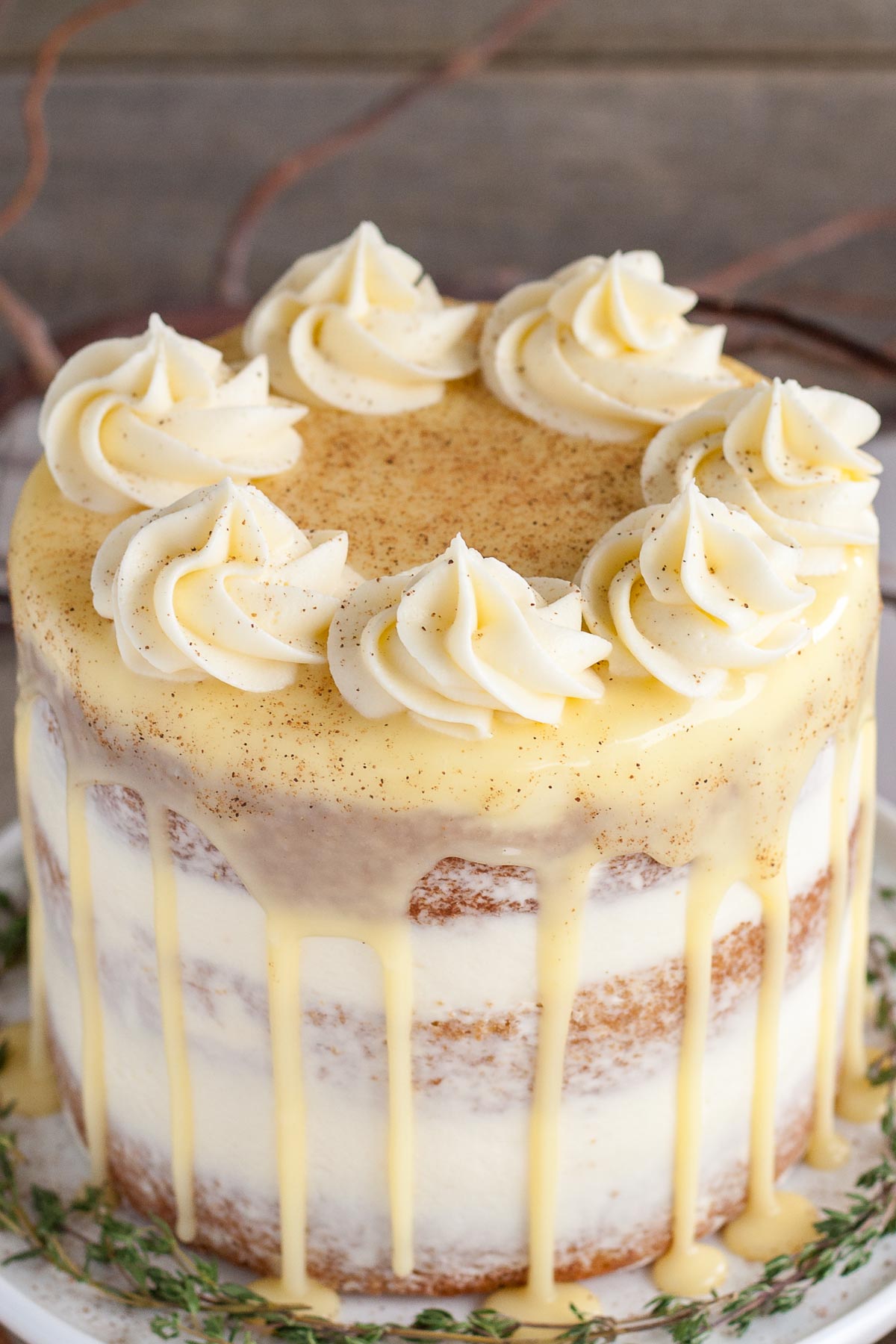 This Eggnog Cake with cream cheese frosting and white chocolate ganache is just the thing to warm you up this Holiday season! | livforcake.com Overhead shot of eggnog cake with rosettes and white chocolate ganache