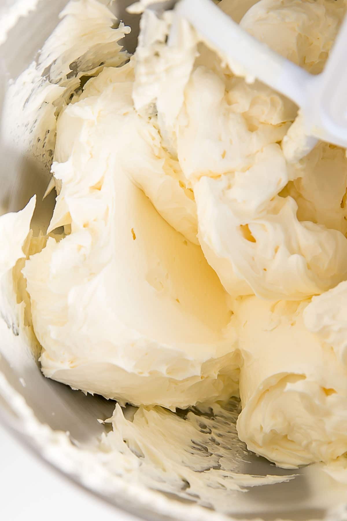 This custard-based German buttercream is made with just a few simple ingredients. Perfect for those who like a rich and silky frosting that isn't too sweet! | livforcake.com German buttercream fluffy and smooth in a stand mixer bowl.