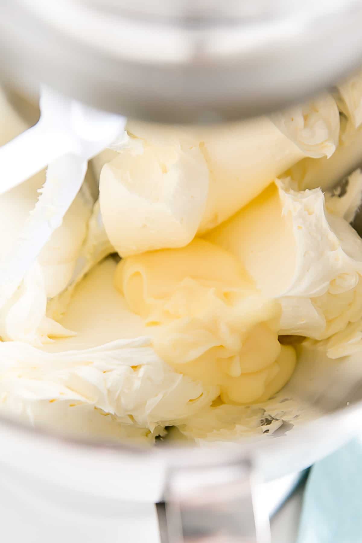 This custard-based German buttercream is made with just a few simple ingredients. Perfect for those who like a rich and silky frosting that isn't too sweet! | livforcake.com Adding pastry cream to whipped butter.