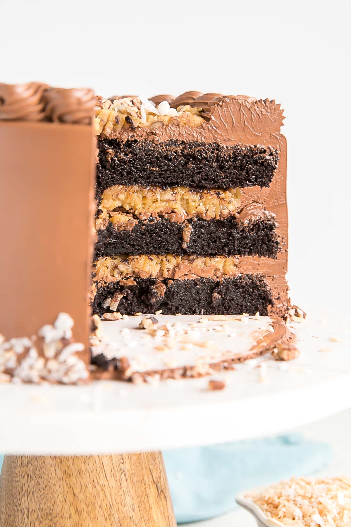 This Classic German Chocolate Cake combines rich chocolate cake layers with a sweet coconut pecan filling and a dreamy chocolate buttercream. | livforcake.com Cross section of cake showing the layers and coconut pecan filling.