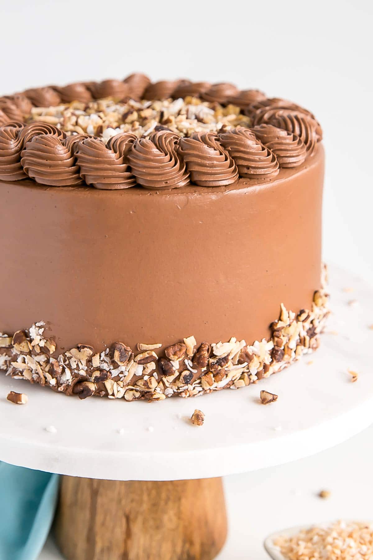This Classic German Chocolate Cake combines rich chocolate cake layers with a sweet coconut pecan filling and a dreamy chocolate buttercream. | livforcake.com Close up of the cake showing the rope border on top.