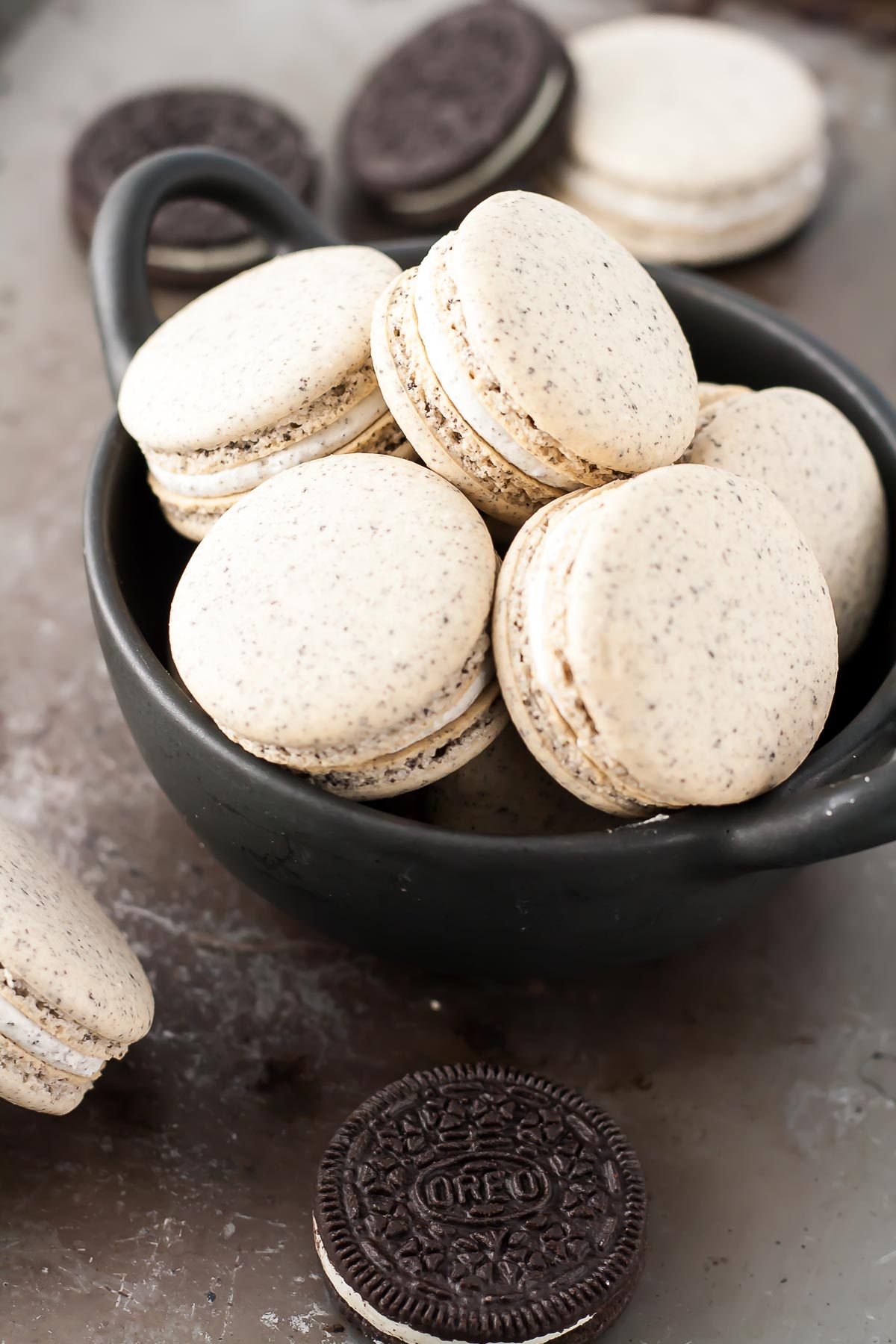 Oreo Macarons! Turn your favourite store-bought classics into something more decadent with these delicate Oreo macarons. | livforcake.com Close up of macarons in a bowl.