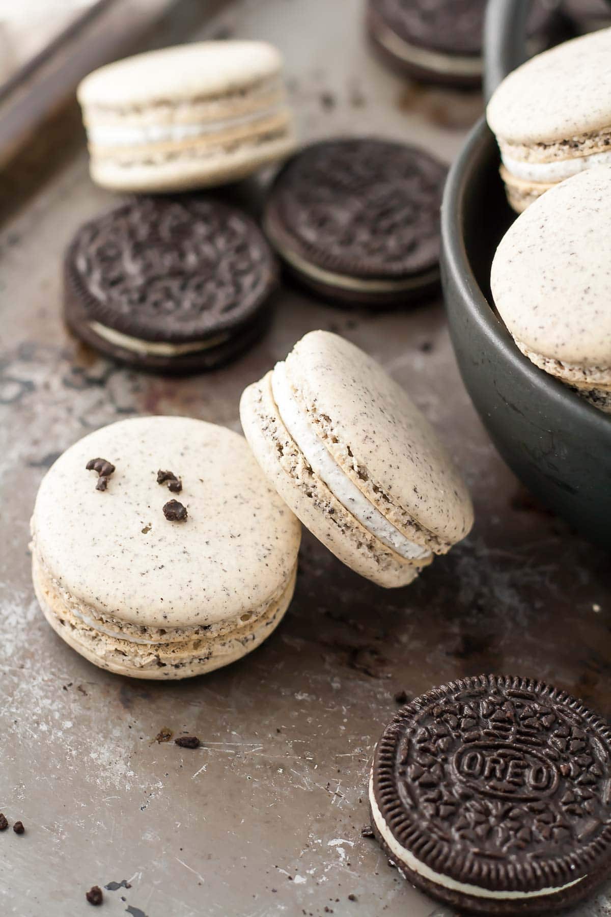 Oreo Macarons! Turn your favourite store-bought classics into something more decadent with these delicate Oreo macarons. | livforcake.com Oreo macarons with Oreo filling on a baking sheet.