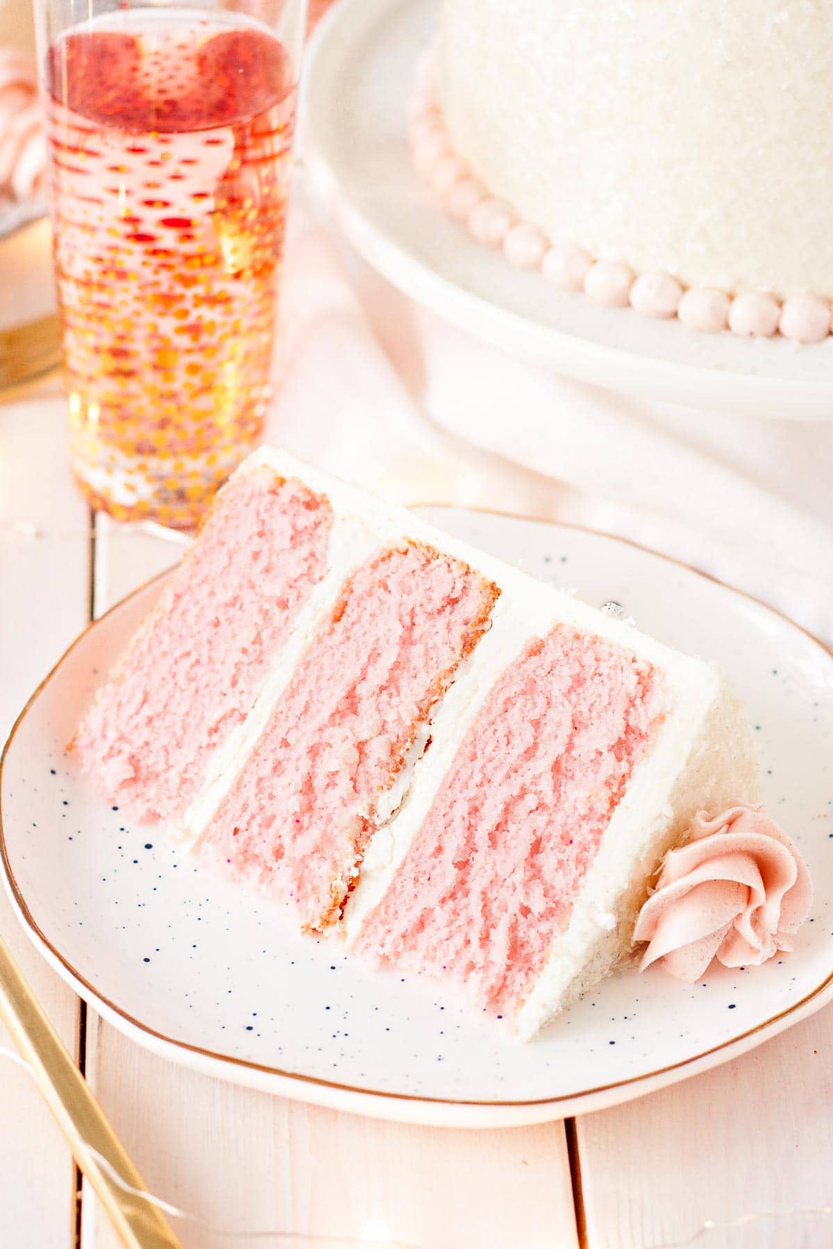 This Pink Champagne Cake is the perfect way to celebrate any occasion or holiday! A champagne infused cake with a classic vanilla buttercream. | livforcake.com Slice of Pink Champagne Cake.