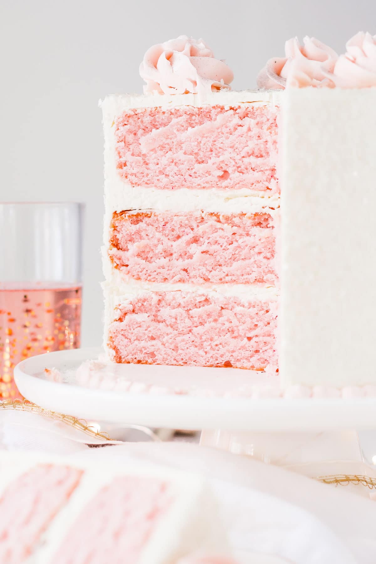 This Pink Champagne Cake is the perfect way to celebrate any occasion or holiday! A champagne infused cake with a classic vanilla buttercream. | livforcake.com Cross section of pink champagne cake with vanilla buttercream.