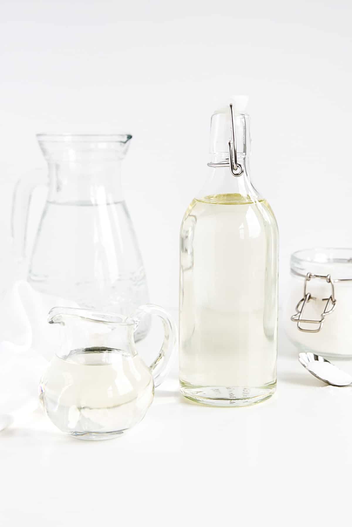 Make simple syrup at home with this quick and easy recipe! The perfect addition to your cakes, cocktails, and iced beverages. | livforcake.com Simple syrup in a bottle shown with water and sugar.