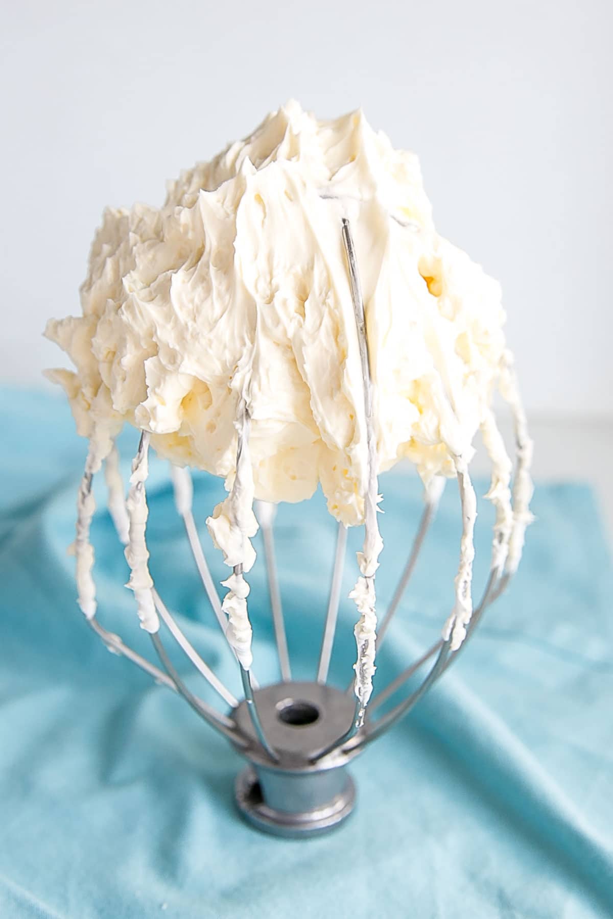 This tutorial on how to make Swiss Meringue buttercream is the only resource you'll need to make the smoothest, silkiest frosting! | livforcake.com Swiss meringue buttercream on a stand mixer whisk.